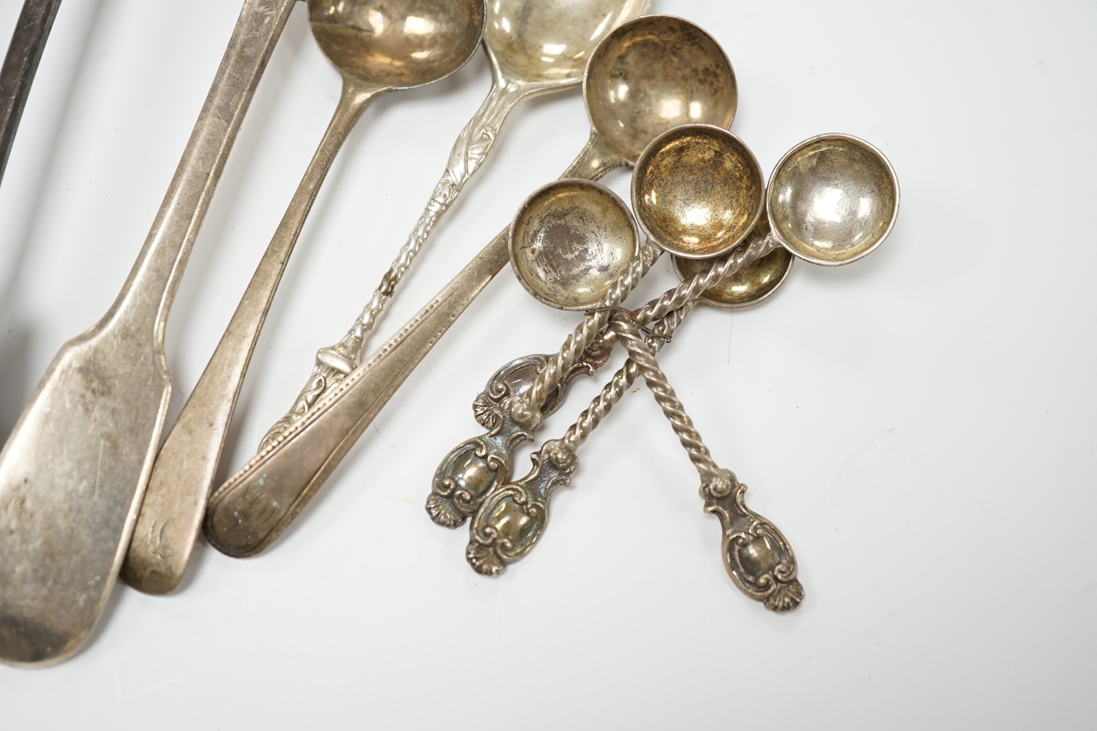 A quantity of mainly 19th century and later silver flatware, including table spoon, dessert spoons, teaspoons, condiment spoons, etc. and other items including two wine labels and a cased 9ct gold mounted amber cigarette